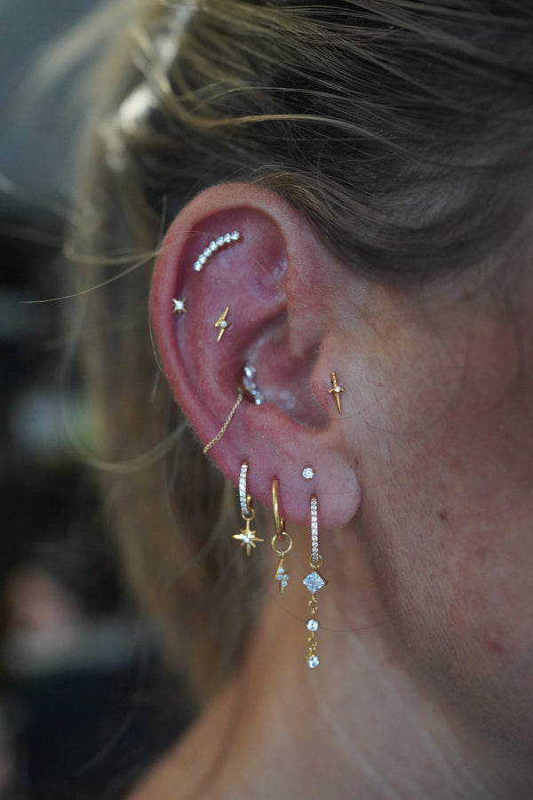 Curated ear with conch, helix and lobe piercings in titanium jewellery