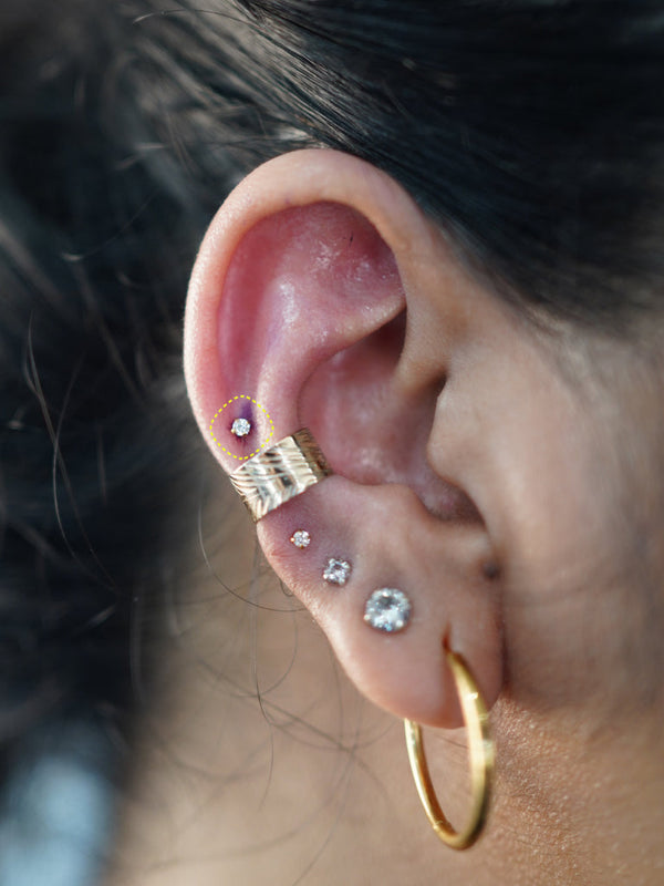 Titanium flat back earring with clear crystal worn in the ear